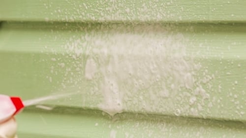 Human Hand Spraying House Wall With Washing Foam