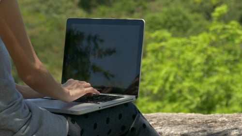Typing on Laptop Outdoors on Sunny Day