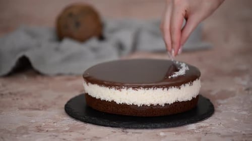 Chocolate Coconut Cake Being Decorated with Coconut Shreds