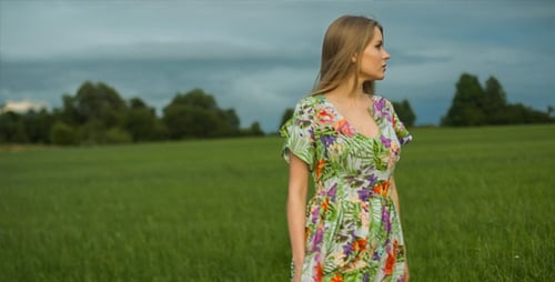 Woman in Floral Dress Walking in Green Field