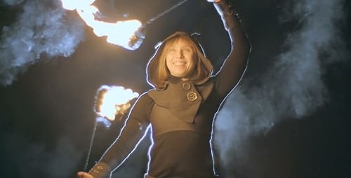 Woman Dancing with Fire Sticks at Night