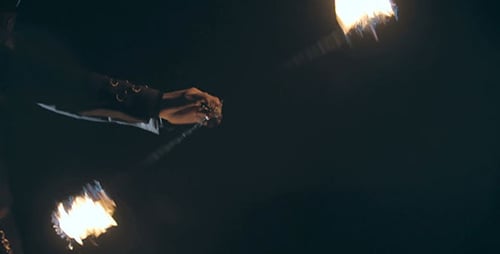 Performer Manipulates Fire Staffs at Night