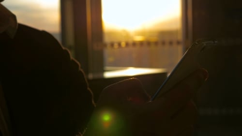Man Typing Text Message At The Airport Terminal