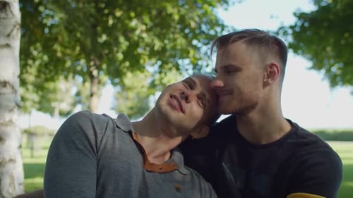 Affectionate Male Couple Sharing a Kiss in Park