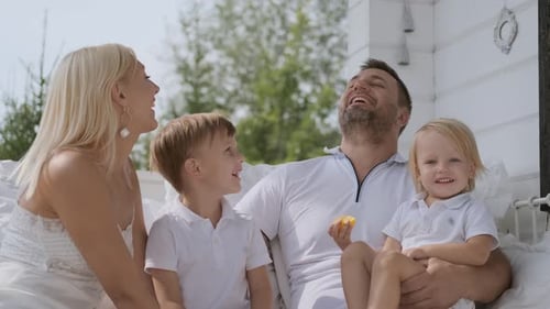 Happy Family Laughing Together on Sunny Porch