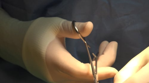 Surgeon Using Surgical Tool Wearing Gloves in Operating Room