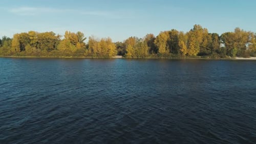 Aerial Drone Footage. Low Flight Over River Water To Autumn Island on Background
