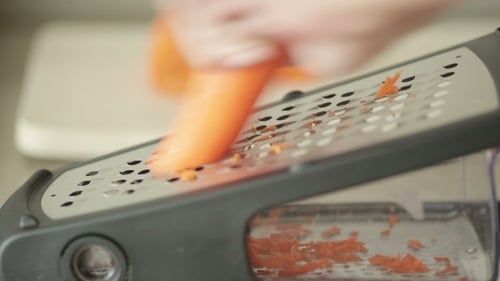 Grating Fresh Carrot in the Kitchen for Cooking