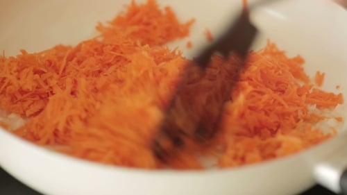 Grated Carrots and Onions Cooking in Frying Pan
