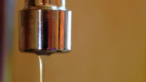 Water Drips from Chrome Faucet in Close Up