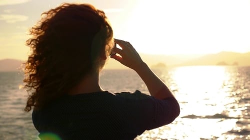 Woman Captures Ocean Sunset with Cell Phone