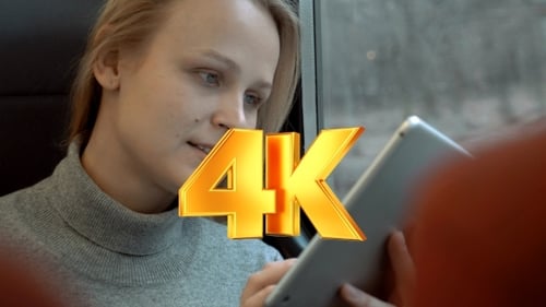 Smiling Woman Using Tablet on Train