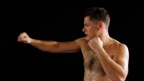 Shirtless Muscular Man Boxing in Studio
