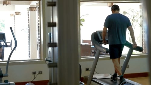 Man Walking on Treadmill in Gym During Daytime