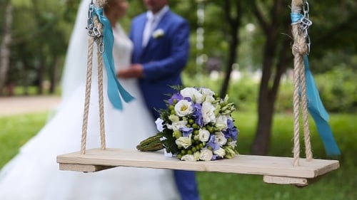 Bridal Bouquet on Swing with Couple Kissing