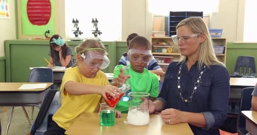 Teacher and students doing science experiment in school classroom