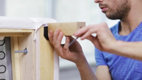 Man Assembling Leg To Sofa