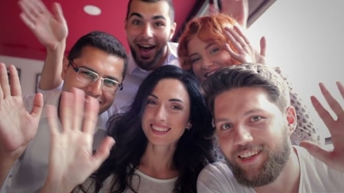 Smiling Friends Waving at the Camera Indoors