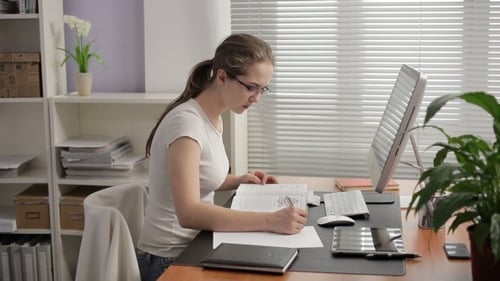 Woman Working at Desk With Computer and Documents