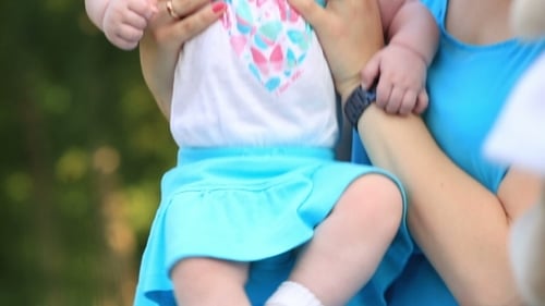 Mother Holding Baby Outdoors in Natural Setting