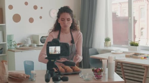 Woman Decorates Muffins on Camera in Her Kitchen