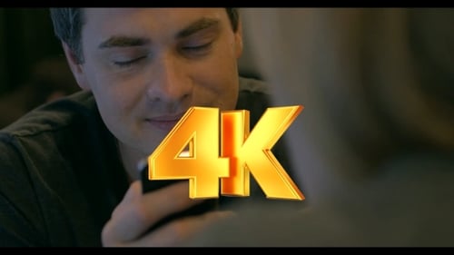 Smiling Man Looks at Phone Indoors