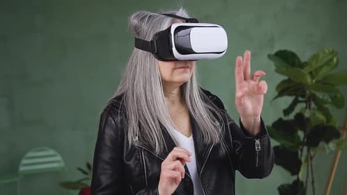 Senior Woman Experiencing Virtual Reality With VR Headset