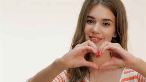Young Woman Makes Heart Shape With Hands