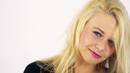 A Young Attractive Woman Smiles at the Camera and Plays with Her Hair - White Screen Studio