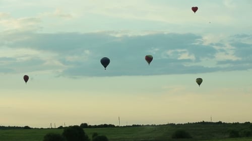 Hot Air Balloons Flying Over Field In Countryside