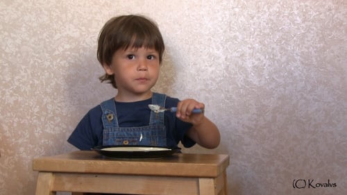 Boy Eating Food at Table Indoors