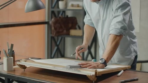 Architect at Drafting Table Creating Architectural Drawing