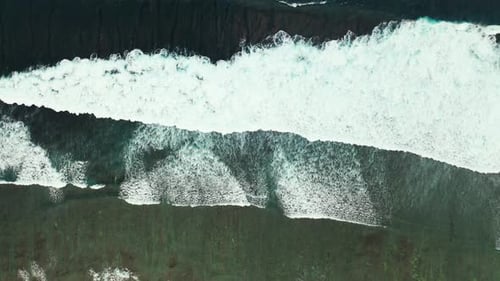 Dramatic sea scene with awesome white waves splashing and foaming on sandy shore of tropical island