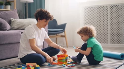 Woman and Child Playing with Building Blocks at Home
