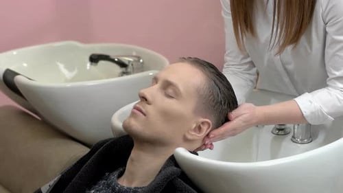 Man Relaxing While Getting Hair Washed in Salon