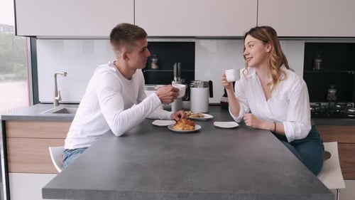 Couple Enjoying Coffee and Croissants at Home