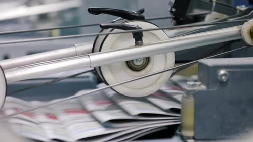 Newspapers Moving Through Industrial Machine