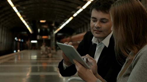 Man and Woman Collaborating with Tablet in Urban Setting