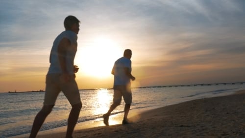 Evening Jogging Along The Beach At Sunset