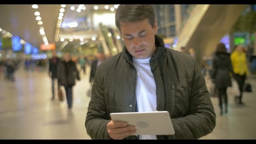 Man Using Digital Tablet In Airport Hall