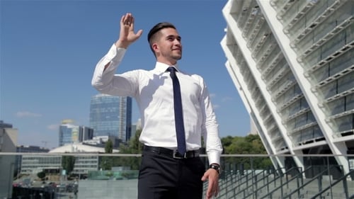 Man Waving on Rooftop in Urban Setting