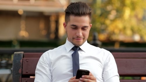 Young Businessman Sitting On a Bench On The Street