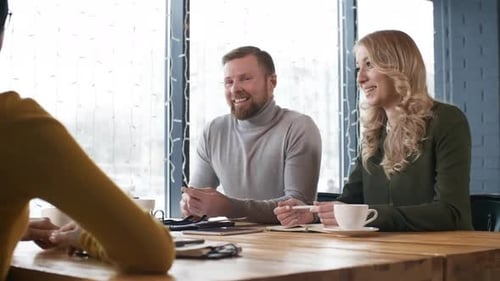 Colleagues Smiling and Chatting with Business Partners in Restaurant