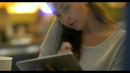 Woman Using Tablet and Phone Indoors