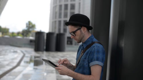 Young Man Typing on Tablet