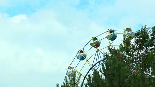Ferris Wheel on the Background Moving Clouds