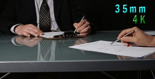 People Signing Document in Business Meeting