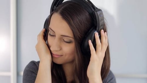 Attractive Young Woman Listening to Music on Headphones
