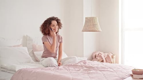 Young Woman Using Mobile for Call in Bedroom