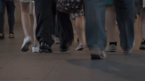 Feet of People Walking on a Crowded City Sidewalk